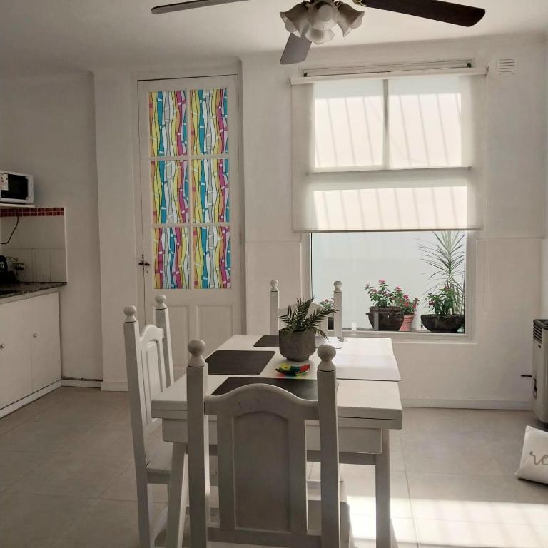 a kitchen with a white table and chairs and a window at La Ñata Apart in Junín