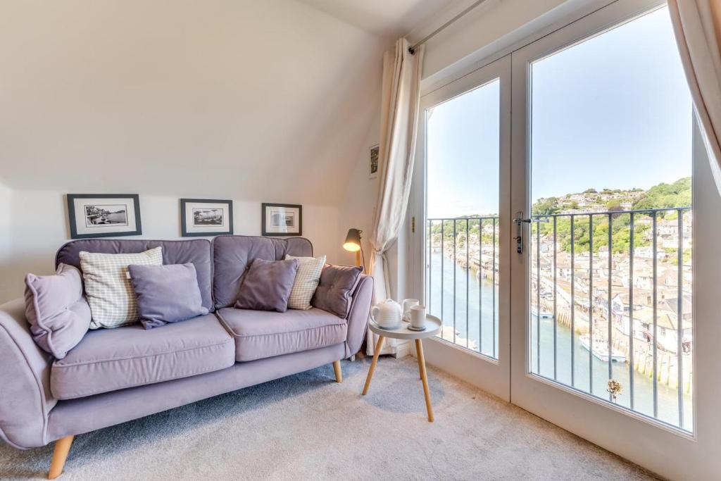 a living room with a couch and a large window at 2 Bed in Looe oc-l30069 in Looe