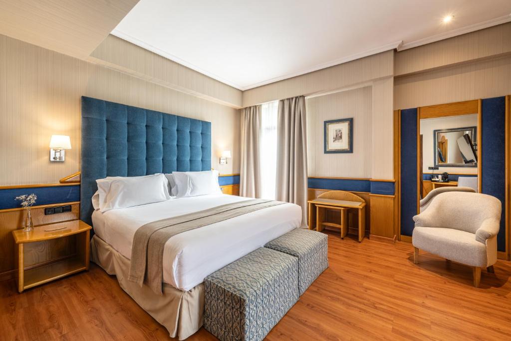 a large bedroom with a large bed and a chair at Agumar Atocha in Madrid