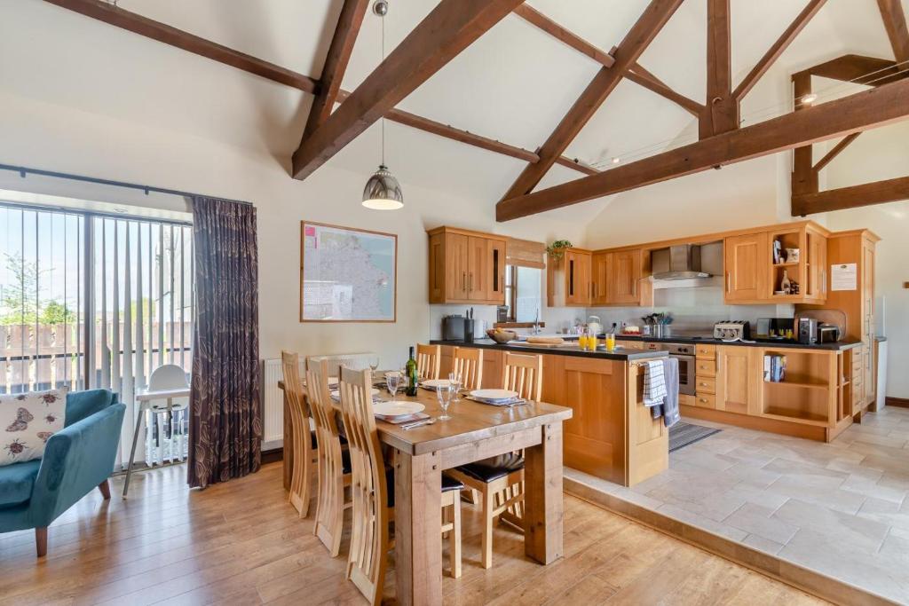 a kitchen with wooden cabinets and a table with chairs at 3 Bed in Thwing oc-t29011 in Thwing