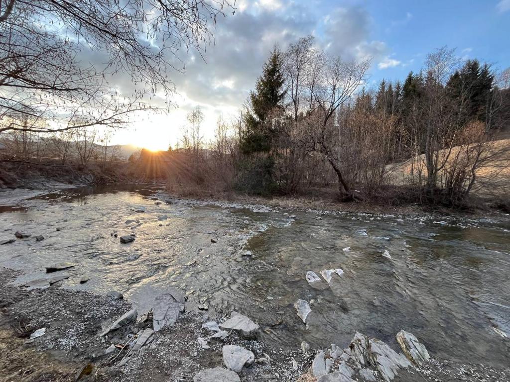 a river with rocks and the sunset in the background at River House in Lazeshchyna