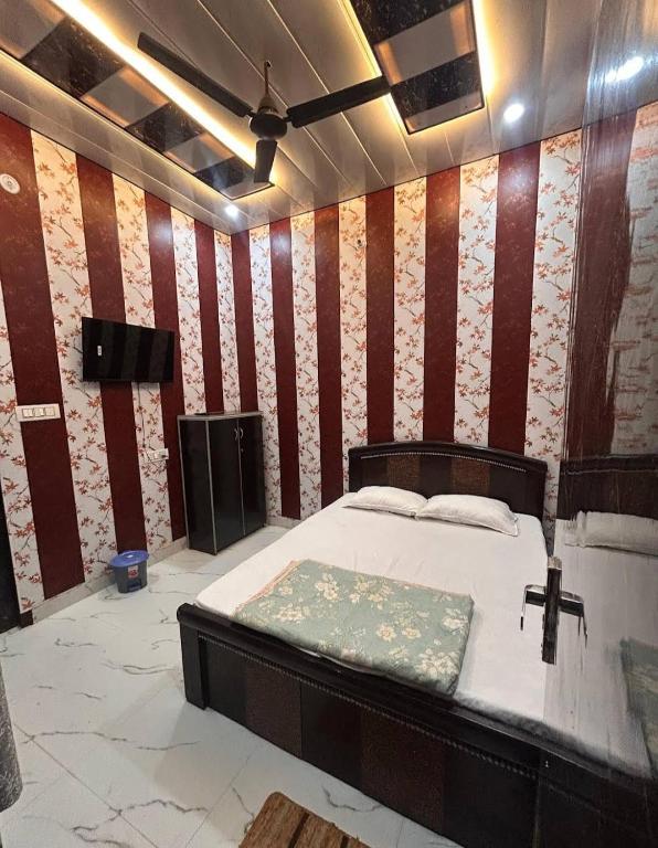 a bedroom with a bed with a red and white striped wall at anandam stay in Vrindāvan