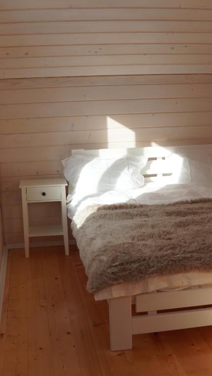 a bedroom with a bed and a nightstand with a white bed sidx sidx sidx at Forest Residens in Krasnik