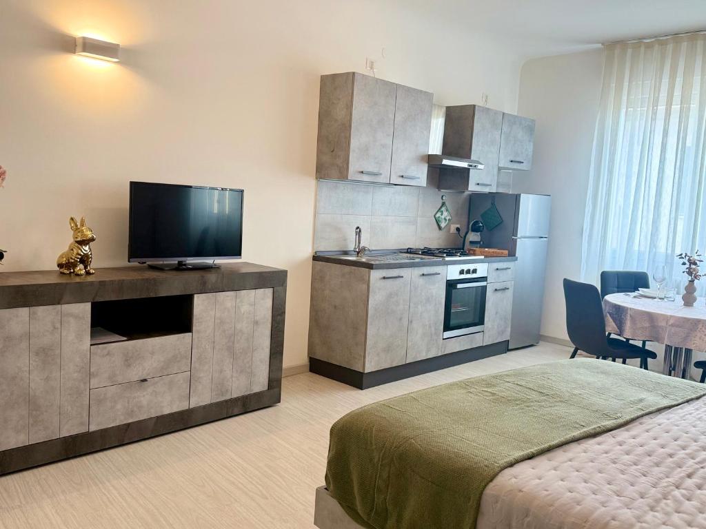 a room with a kitchen with a bed and a television at Loft moderno nel cuore del Centro Storico - spazioso & luminoso WiFi veloce- Tutto a piedi in Pordenone