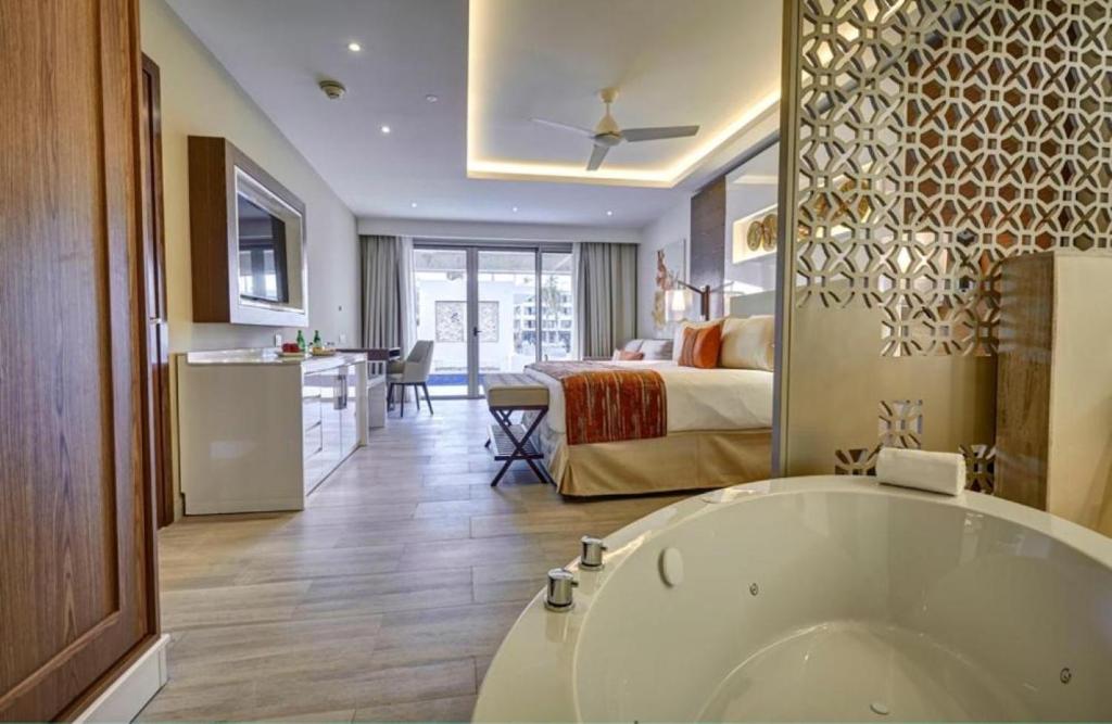 Suite with whirlpool tub, king bed, kitchenette, and balcony access.