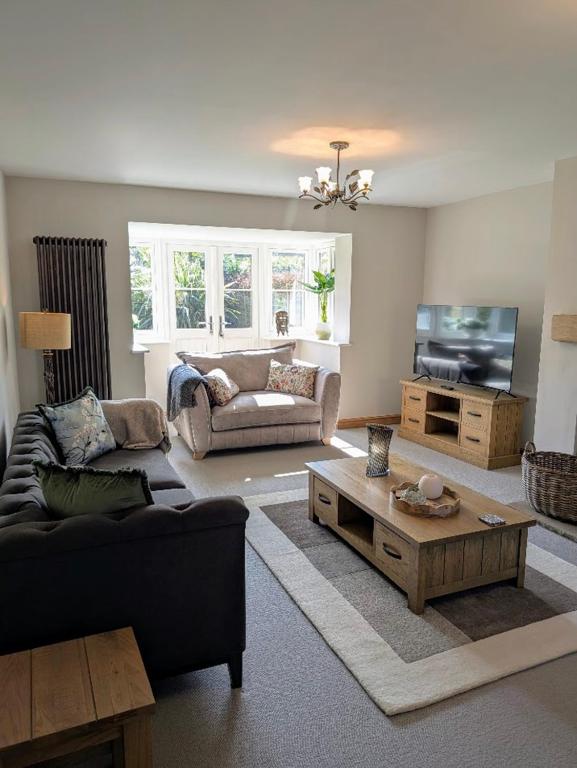a living room with a couch and a coffee table at Coastal Whisper Sleeps 10 with Parking in Reighton