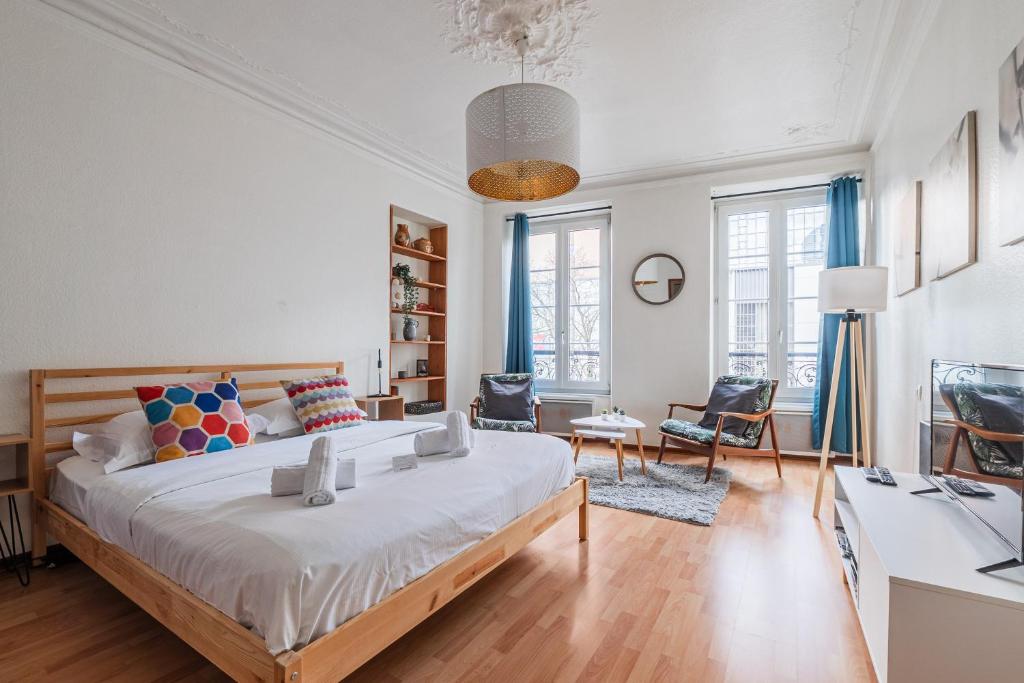 a bedroom with a large bed and a living room at Le Sebastopol - Appt moderne de 65m2 in Strasbourg