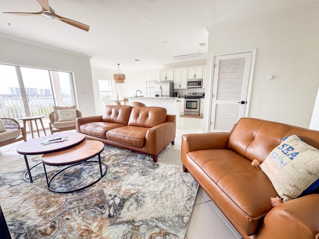 a living room with two leather couches and a table at Destin Harbor Escape in Destin