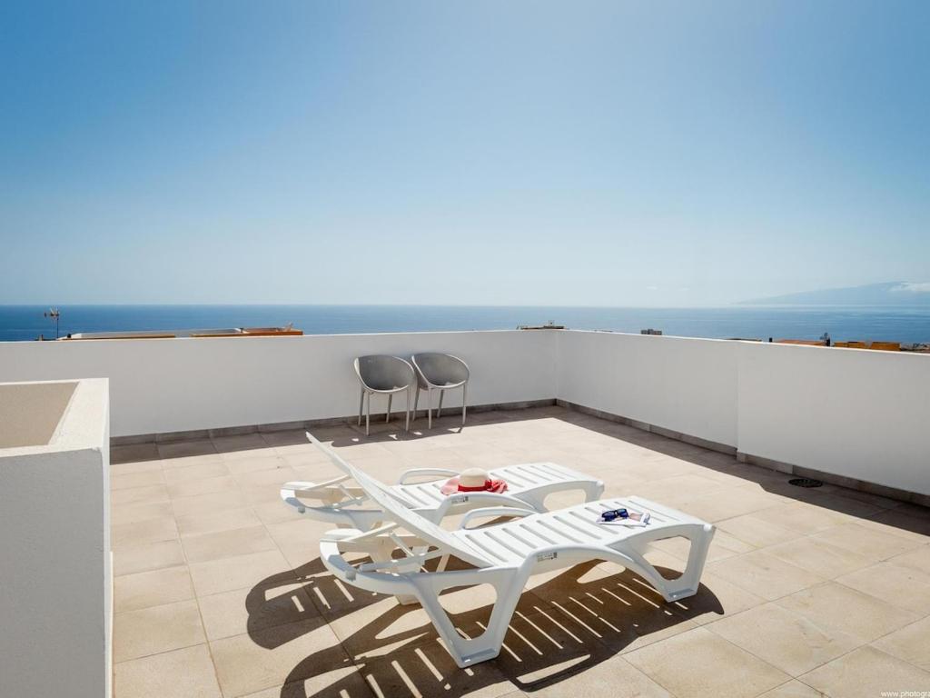 a balcony with a table and chairs and the ocean at Atico Vega Penthouse in Adeje
