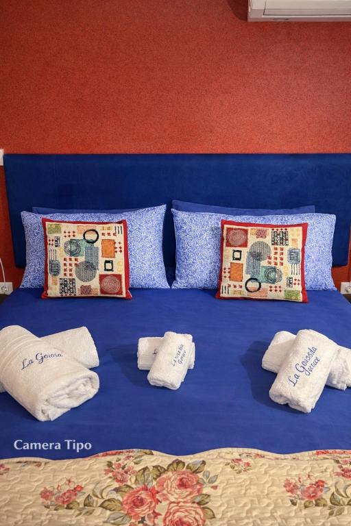 a blue bed with towels and pillows on it at La Rosa Blu in Gerace