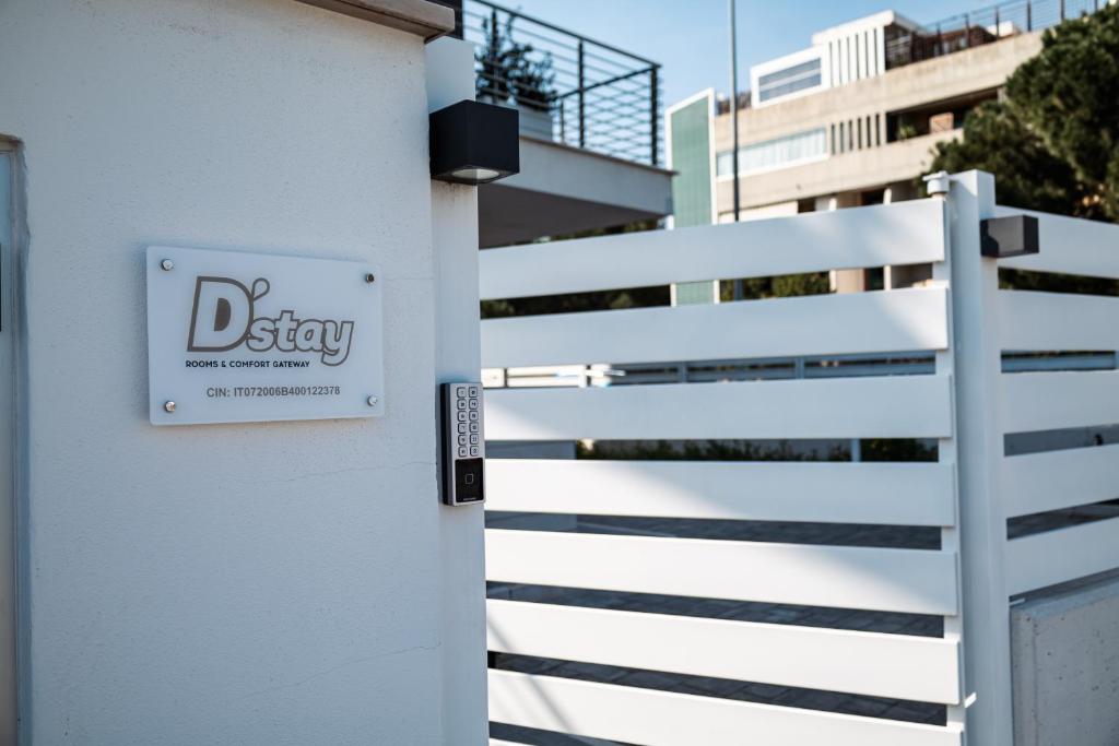a sign on a white fence in front of a building at D'Stay in Bari