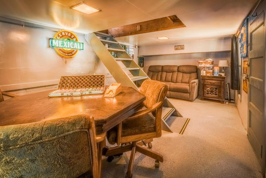 a living room with a table and a spiral staircase at Gonzalez Cabin in Running Springs