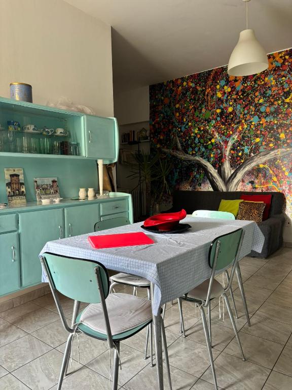 a table and chairs in a kitchen with a painting at L’Albero Colorato in Candelo