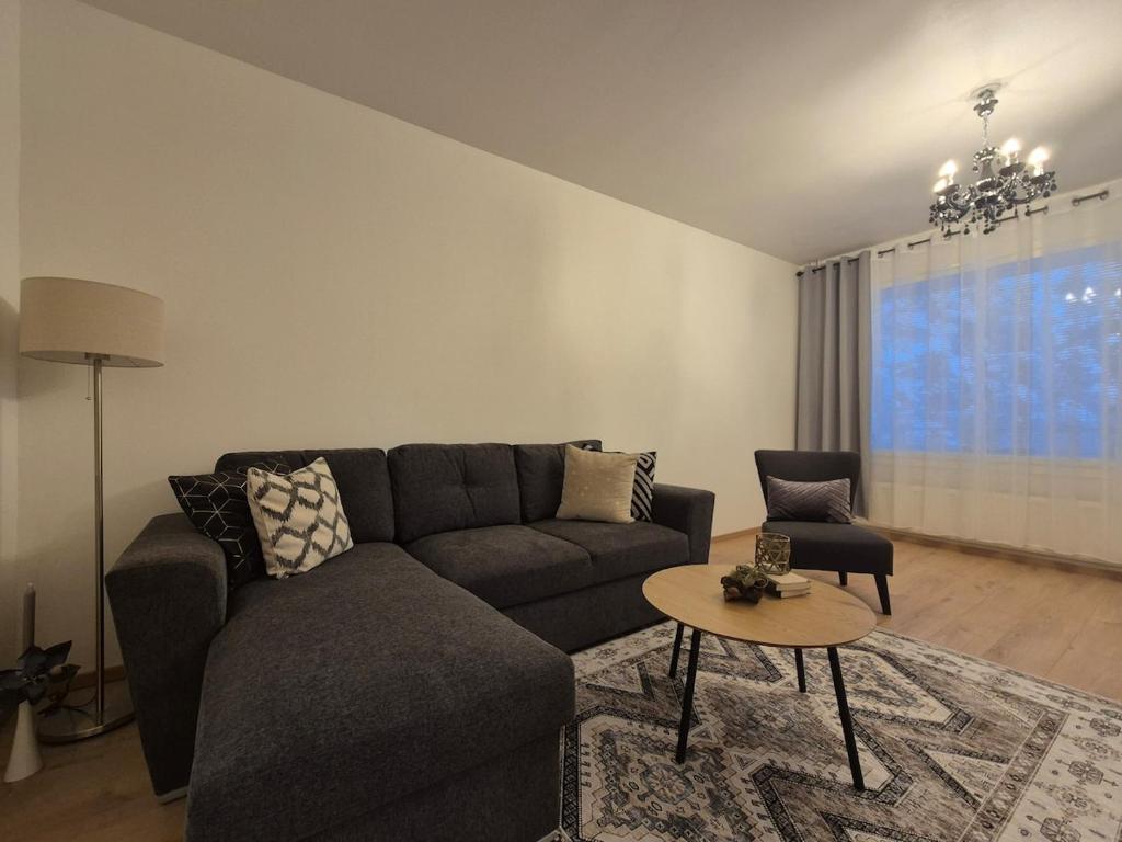 a living room with a couch and a table at Azure Nordic Retreat in Rauma