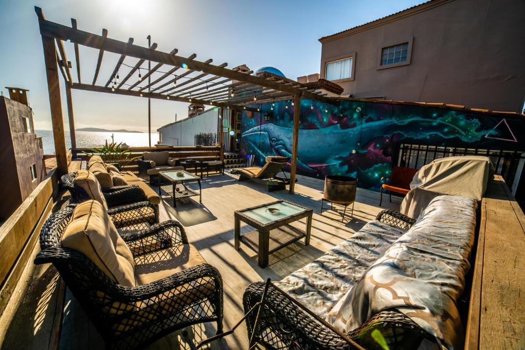 a patio with couches and a mural on a building at Baja Beach House Pools, Beaches & Ocean View in San Antonio del Mar