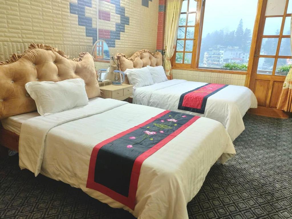 a hotel room with two beds and a window at THANH XUAN Hotel in Sapa