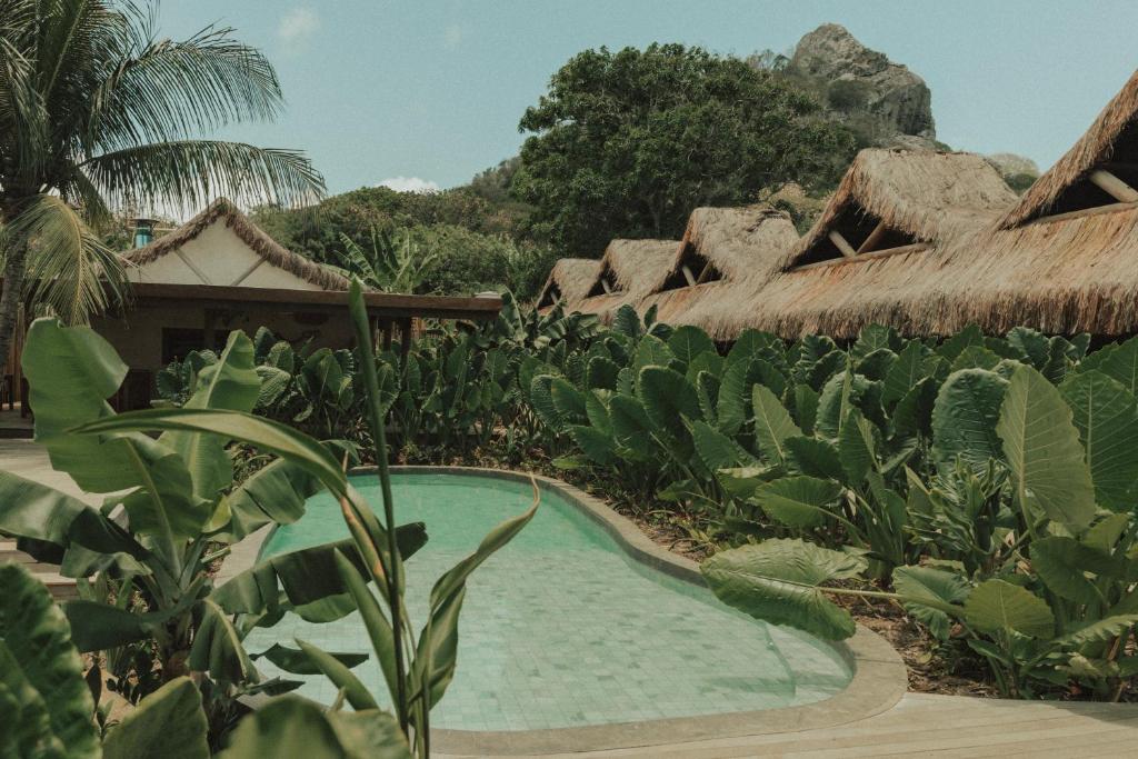 a resort with a swimming pool and some plants at Pousada Topázio by Amana in Fernando de Noronha