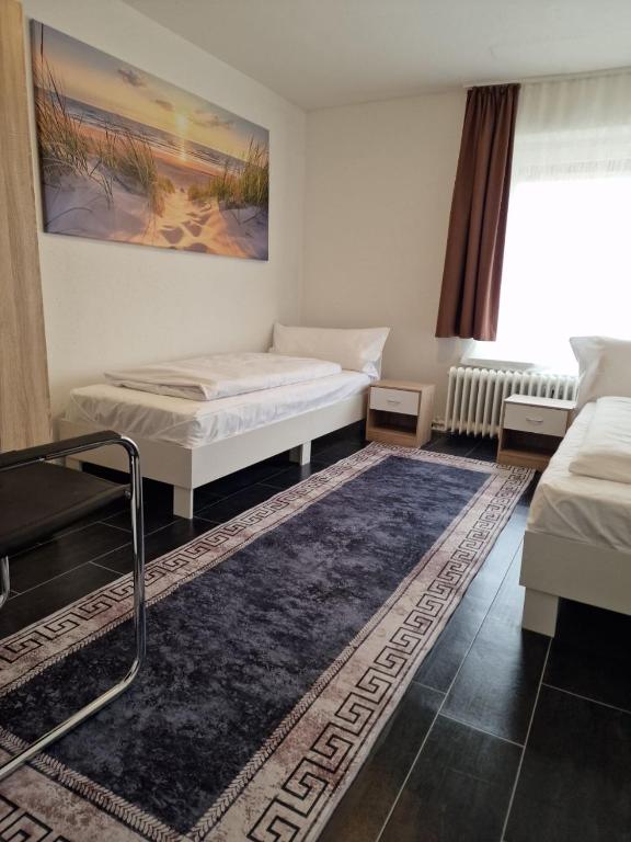 a room with two beds and a rug at Apartments by Pension Pale Bach in Bad Hersfeld