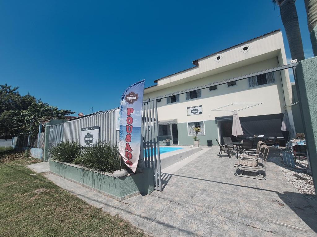 a building with a patio with a table and chairs at Pousada Recanto Vo da Maria com Piscina a 440mt da praia in Pontal do Paraná