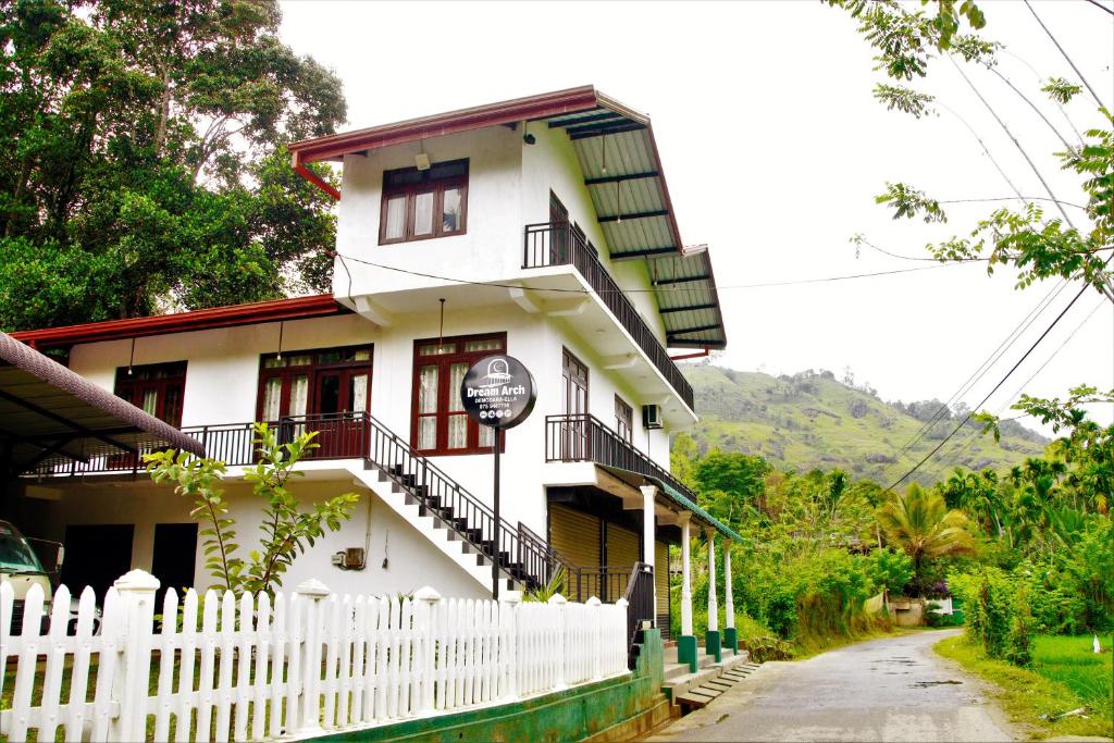 a white building with a white picket fence in front of it at Dream Arch ella in Demodera