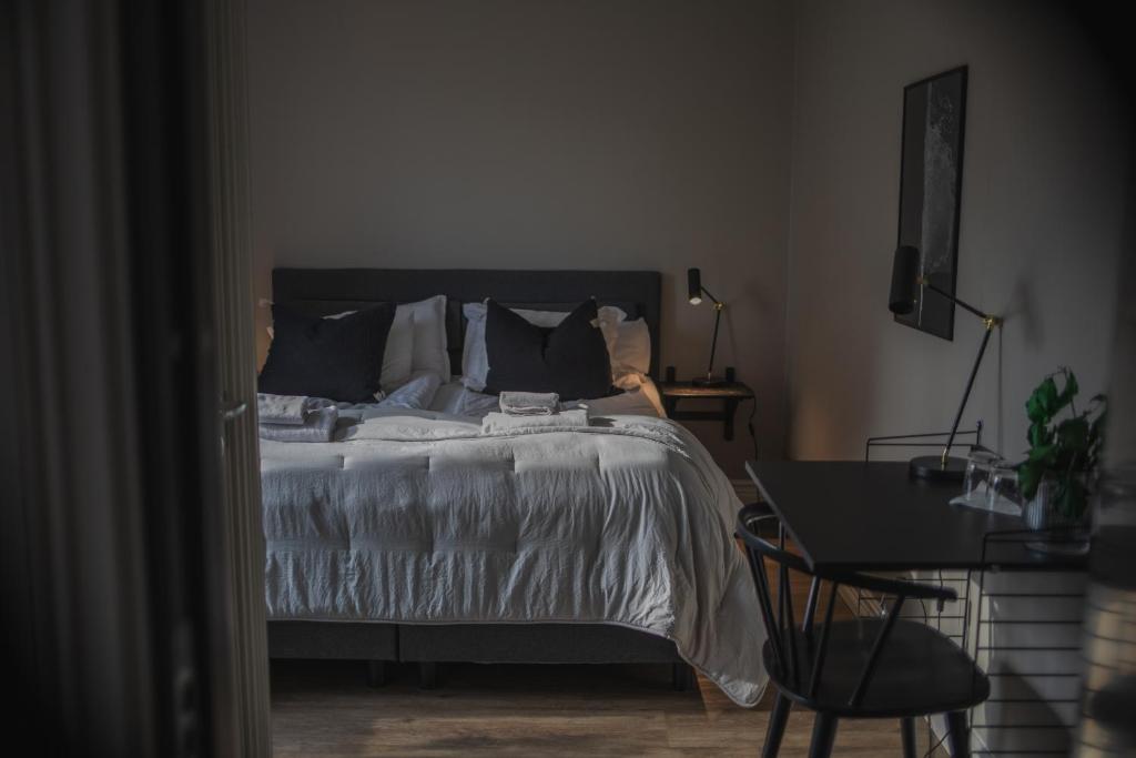a bedroom with a bed and a table with a chair at Västerhöjdsgården in Skövde