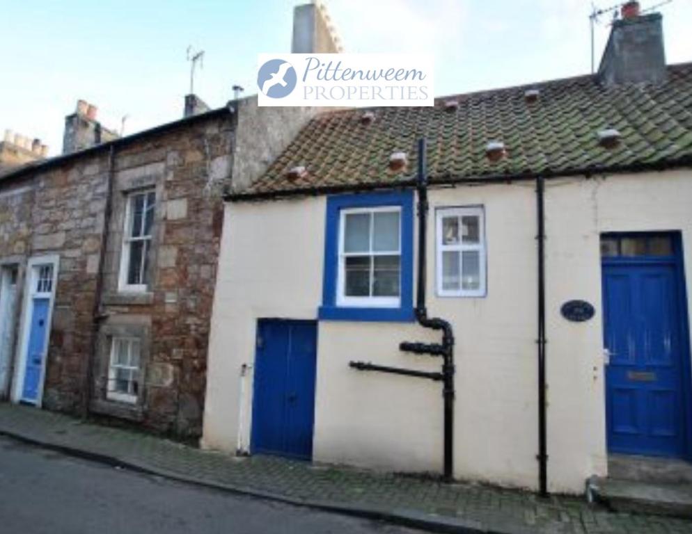 a building with blue doors on a street at Catherine Cottage seaside home in Anstruther