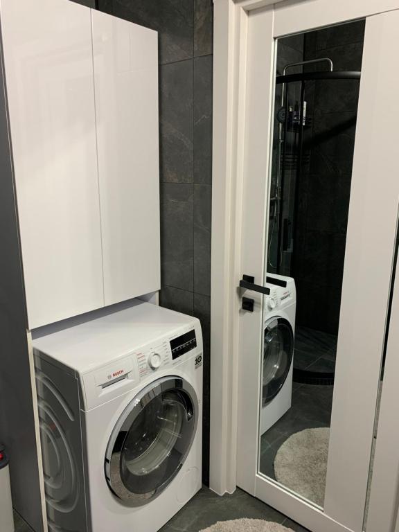 a laundry room with a washing machine and a mirror at Стильна смарт-квартира in Odesa