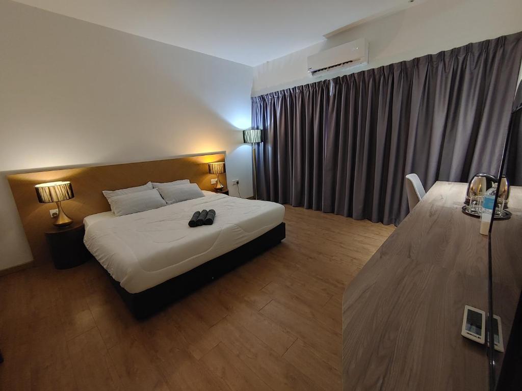 a hotel room with a bed and a table at Sofea Roomstay Hotel in Kota Bharu