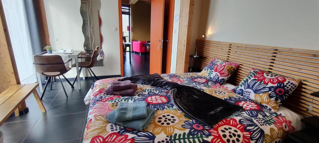 a bedroom with a bed with a colorful blanket at B&B Casa de Paja in Sint-Truiden