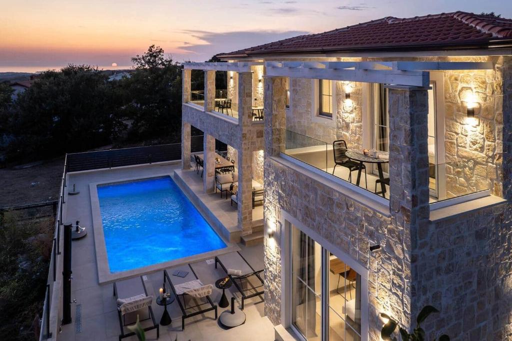 an aerial view of a house with a swimming pool at Villa Bella Vista with Pool and Seaview in Labinci