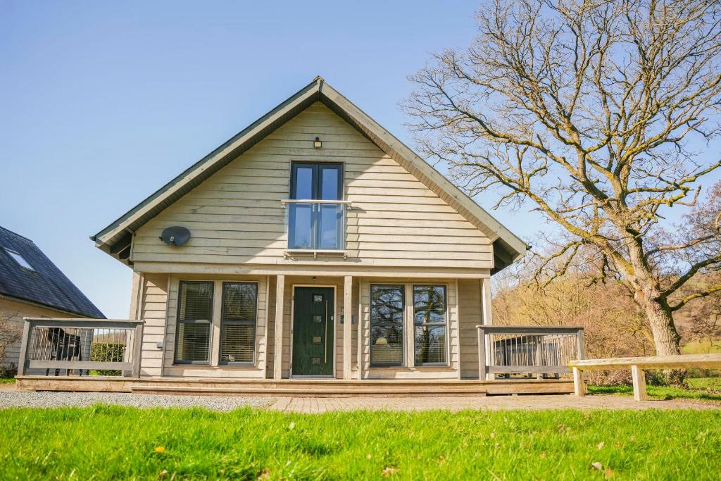 a house with a green door and a tree at Oak Lodge in Knighton