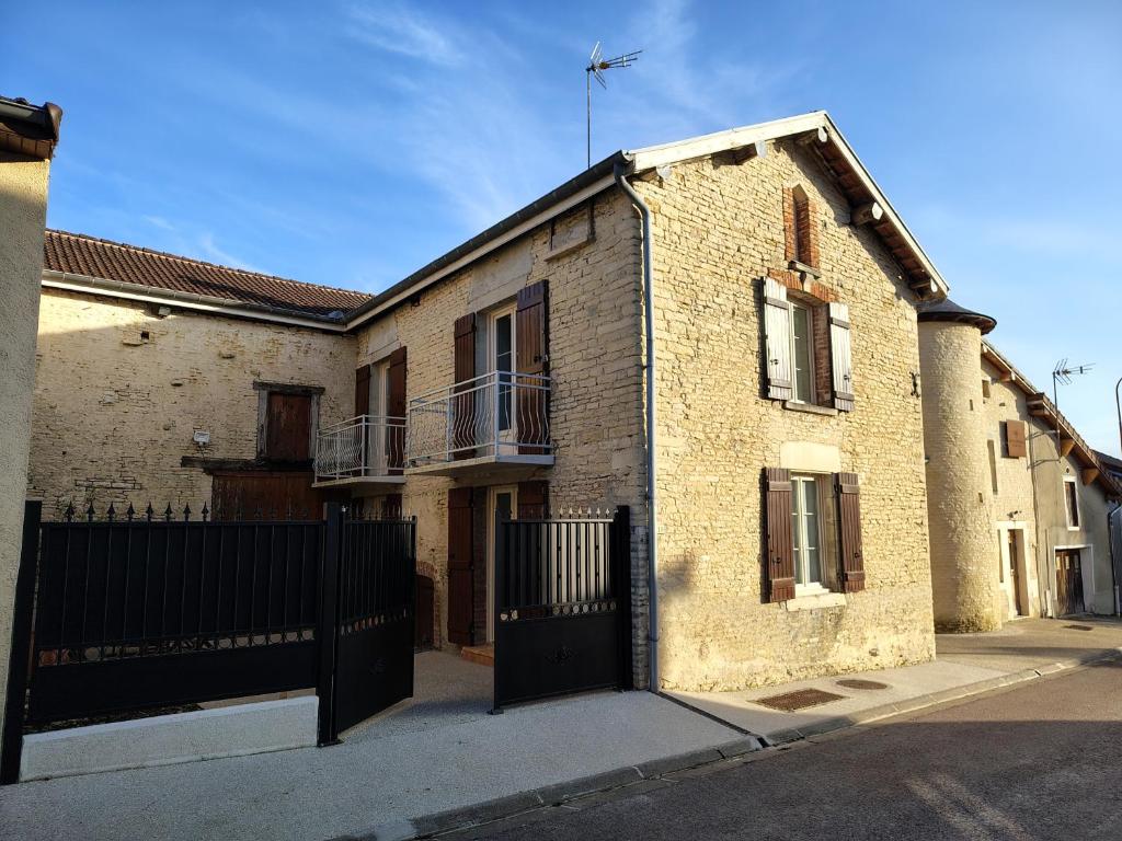 a brick building with a black gate in a street at Entre pierre & vigne in Arrentières