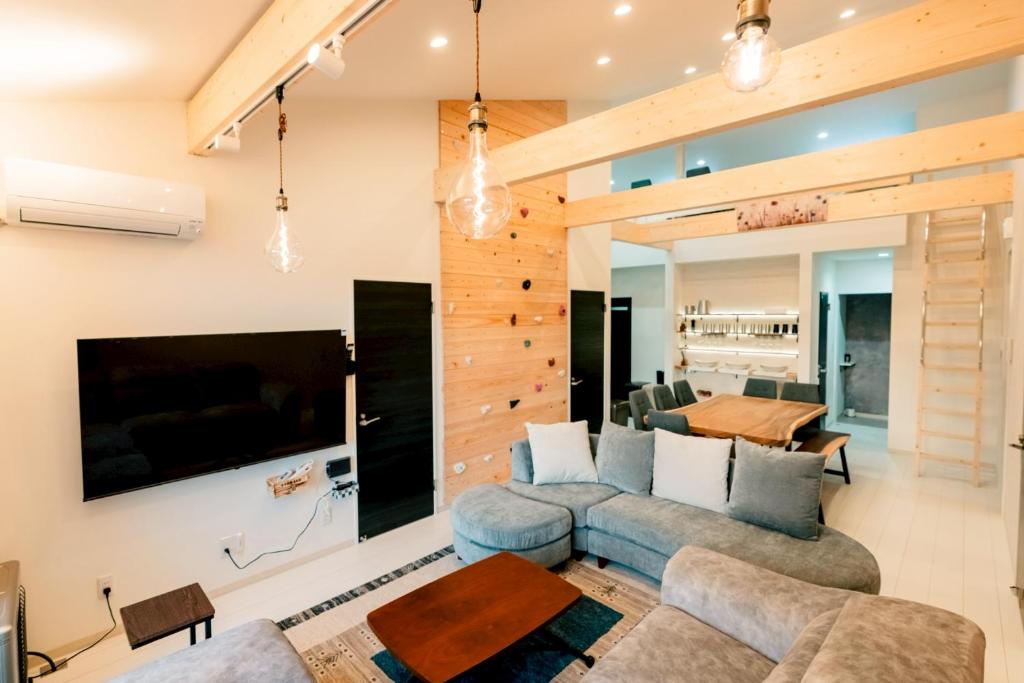 a living room with a blue couch and a tv at ステラガーデン in Kami-furano