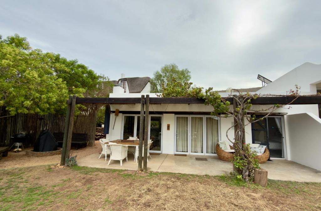 a house with a patio with a table and chairs at Featherwood Cottage in Malgas