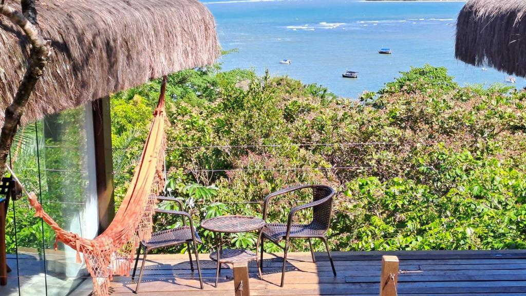 a patio with chairs and a table and a view of the ocean at Alizées Moreré in Ilha de Boipeba