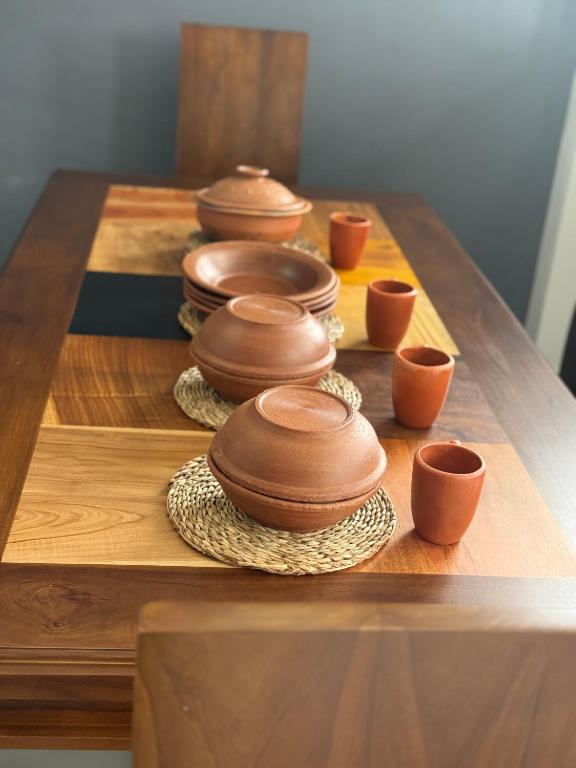 a group of bowls and plates on a wooden table at Naadee villa in Ekala