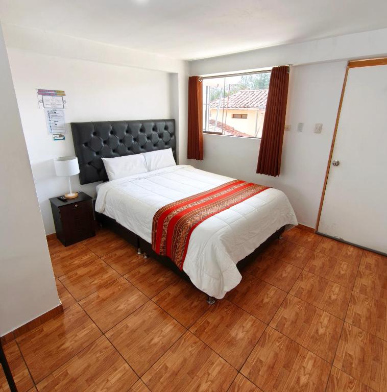 a bedroom with a large bed and a window at Hostal Cusco de mis Sueños in Cusco