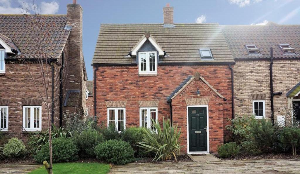 a red brick house with a black door at Sandy Toes, The Bay, Filey in Filey