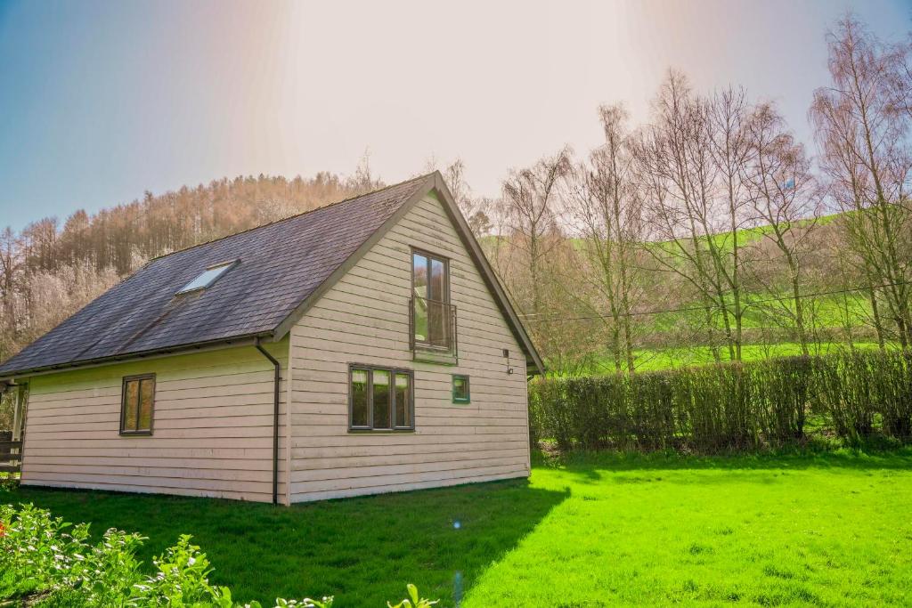 a small white house in a field of grass at Willow Lodge in Knighton
