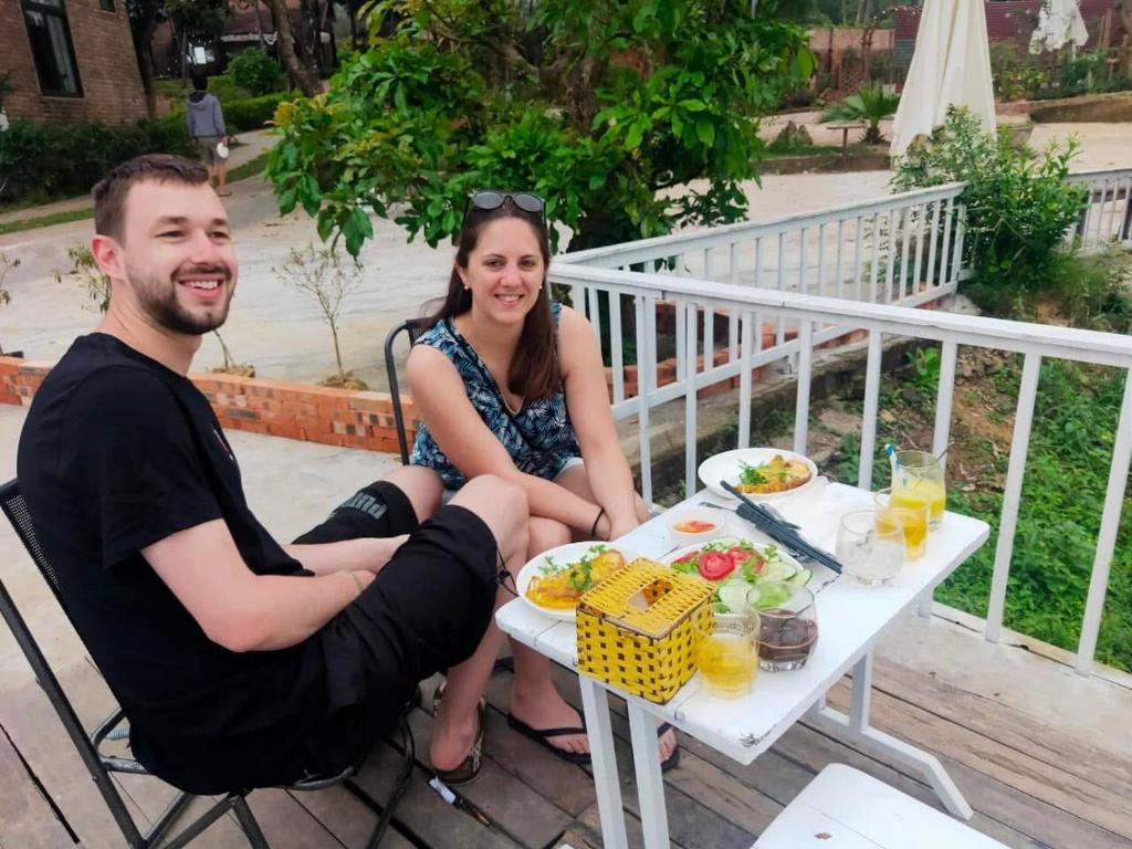 a man and a woman sitting at a table with food at Son Home Garden in Hue