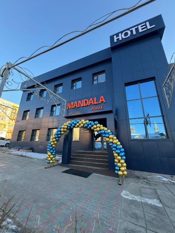 a hotel with an arch in front of a building at Mandala Hotel Erdenet in Erdenet