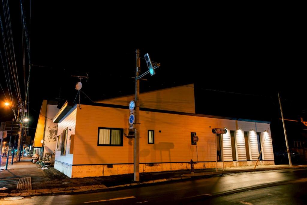 a building on the corner of a street at night at ララリカ in Kami-furano