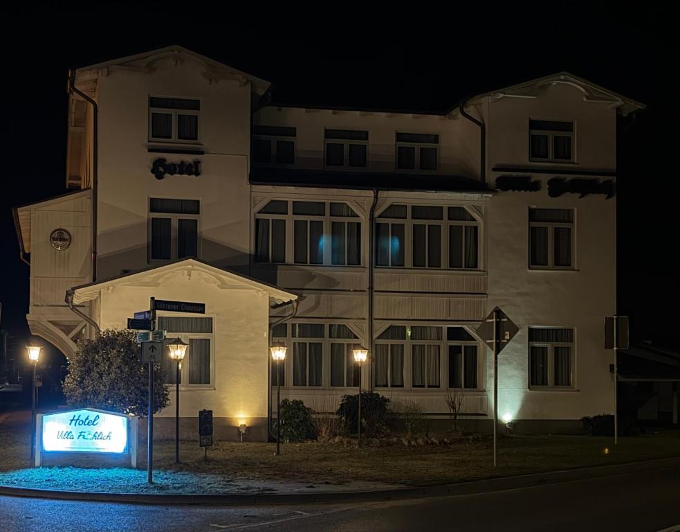 a building with a sign in front of it at night at Hotel Villa Fröhlich in Baabe