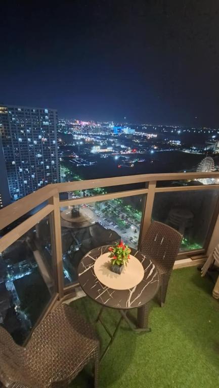 a table and chairs on a balcony at night at Manila Bay City Lights in Manila