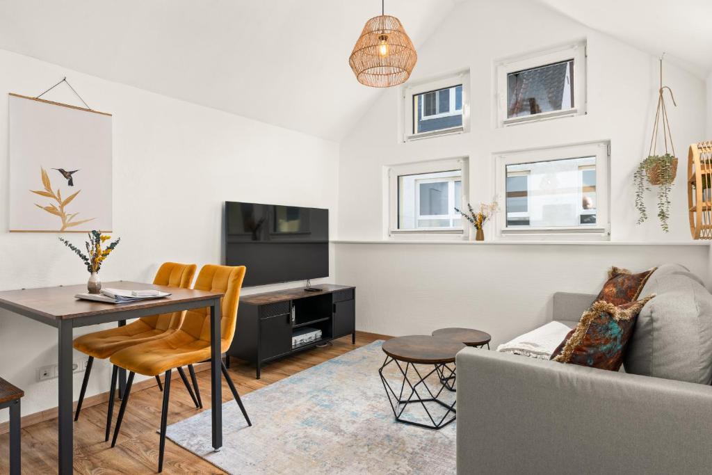 a living room with a couch a table and a tv at KOLIBRI - Design Maisonette - Nintendo Switch, Streaming, Bikestore, E-Wallbox in Marburg an der Lahn