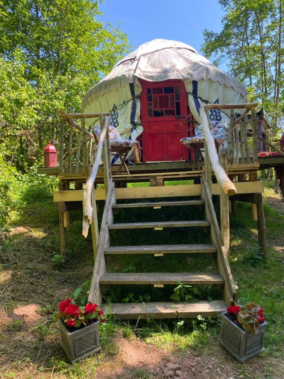 a gazebo with stairs and a red door at The Shangri La Sunset Yurt in Tenbury