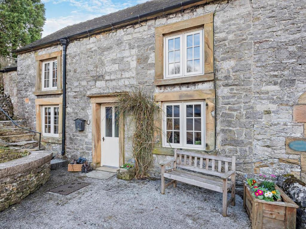 a stone house with a bench in front of it at 2 Bed in Buxton oc-95993 in Hartington