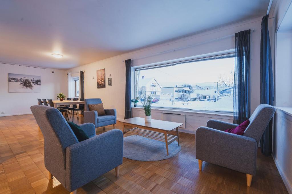 a living room with chairs and a large window at NORD Apartment in Tromsø