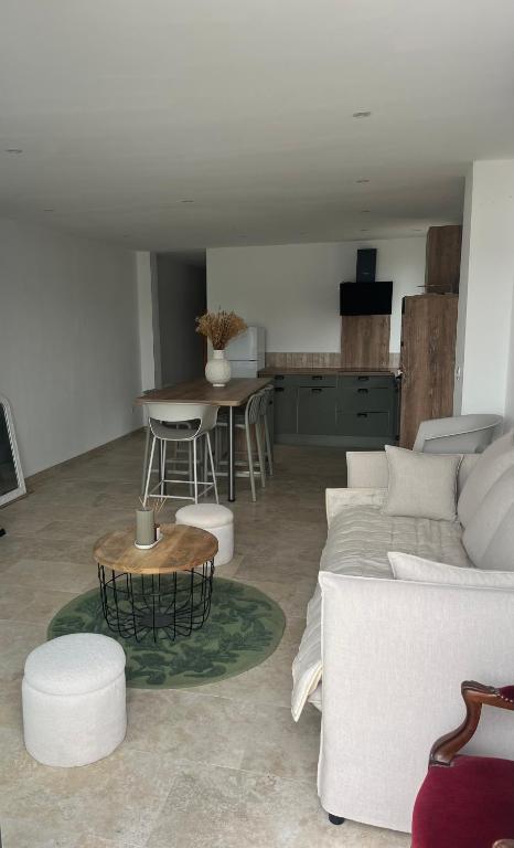 a living room with a white couch and a table at Les clés de Jules in Gruissan