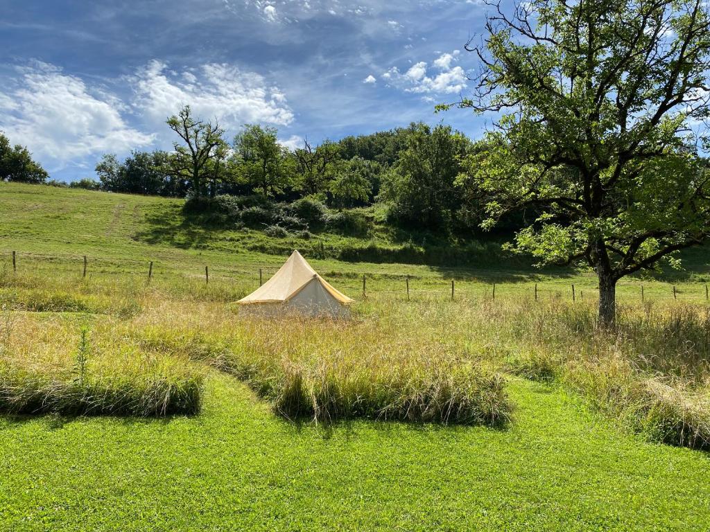 a tent in the middle of a field at Camping équipé : Vallon de Laborie in Astaillac